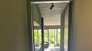 A hallway leading to a balcony with a view of greenery. - Garden Jewel Design Apartment (Minusio)