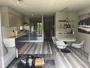 A modern kitchen with a dining area, a sofa, and a coffee table.