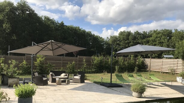 A patio area with outdoor furniture, a pool, and a wooden fence. - Small welcoming house in a farmhouse. (Parisot)