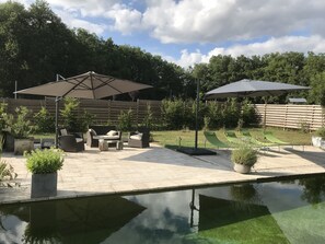 A patio area with outdoor furniture, a pool, and a wooden fence. - Small welcoming house in a farmhouse. (Parisot)