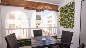 A balcony with a table and chairs, a lantern, and a decorative wall. - Alcazaba Square Central Beach (La Herradura)