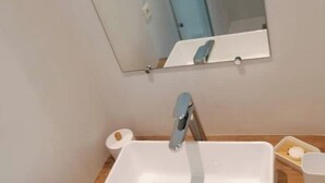 A bathroom with a white sink, a mirror above it, and a wooden countertop. - "La Source", Location Saisonnière Proche Cognac (Cherves-Richemont)
