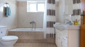 Ein Badezimmer mit Toilette, Badewanne und Waschbecken.