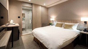 A modern hotel room with a large bed, bedside tables, a desk, a shower area, and a bathroom. - COMMA Boutique Hotel (Taipei)
