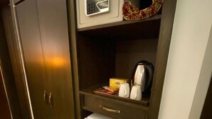 A compact kitchenette with a microwave, a small refrigerator, and a coffee maker. - Grand Mongolia Hotel (Mekhtar)