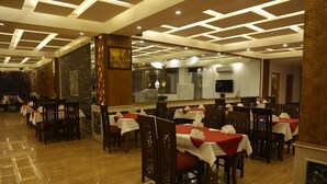 A restaurant with tables set for dining, a polished wooden floor, and a modern ceiling design. - Grand Mongolia Hotel (Mekhtar)