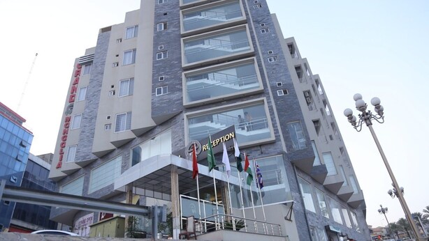 A multi-story hotel with a reception area at the ground level, featuring a modern architectural design with glass windows and a prominent reception sign. - Grand Mongolia Hotel (Mekhtar)