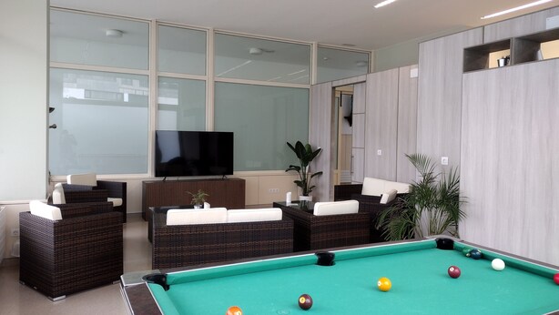 A pool table with balls, a television, and seating areas with cushions. - Hospedería San Froilan  (Lugo)