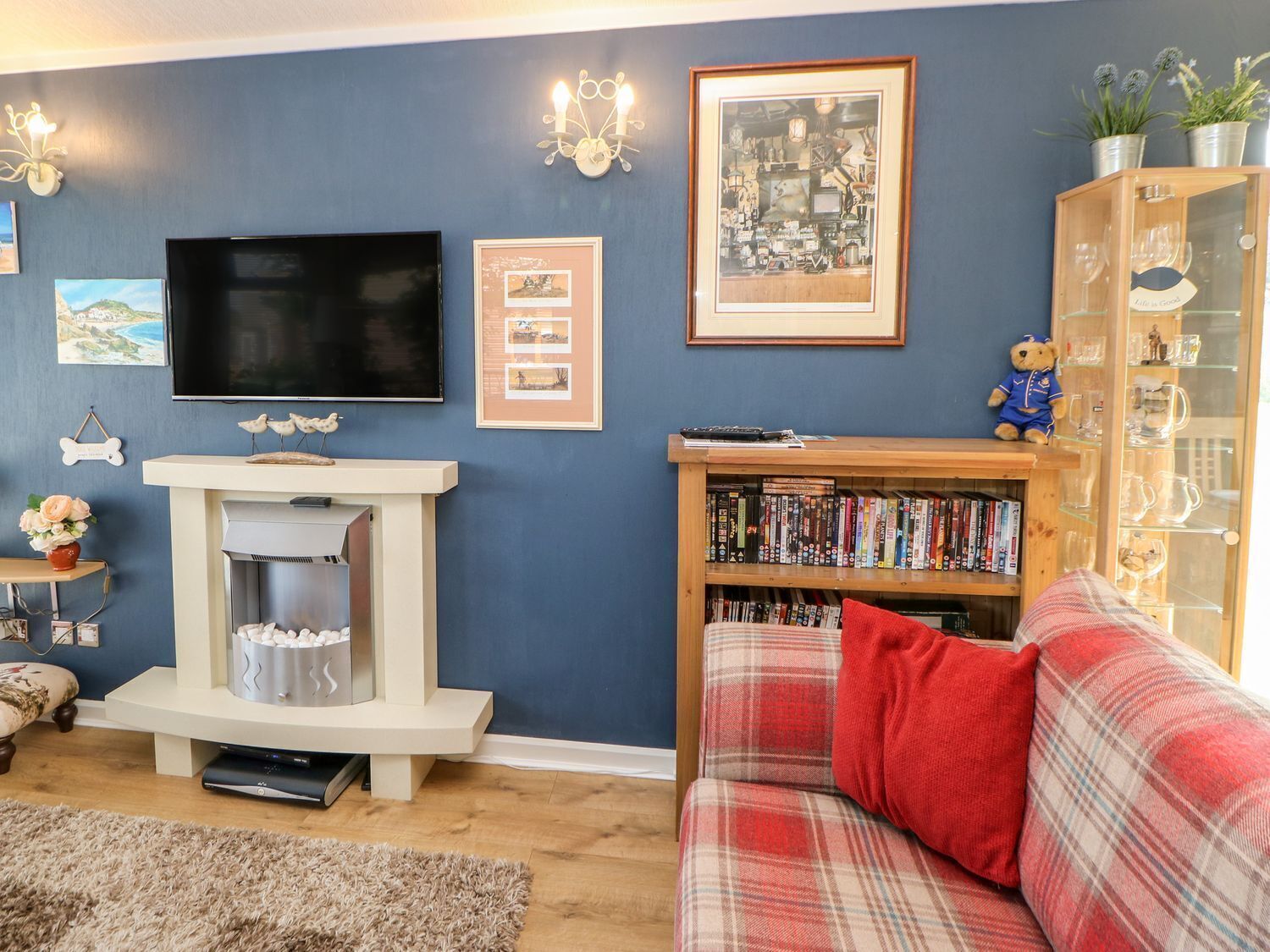 A living room with a fireplace, a television, a bookshelf, and a sofa.