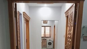 A hallway leading to a laundry area with a washing machine and a window. - Al-Rehman Palace 1 (Mekhtar)