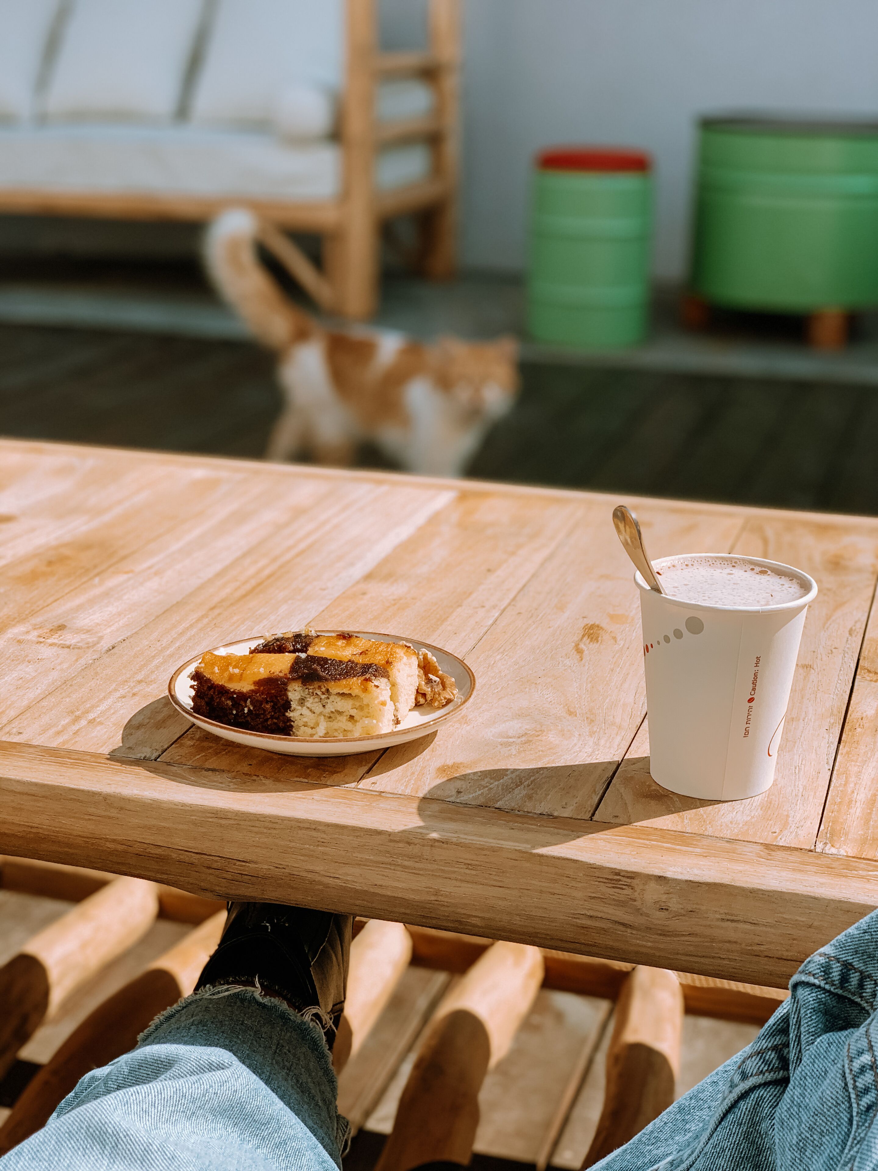 A wooden table with a plate of food and a cup of coffee.