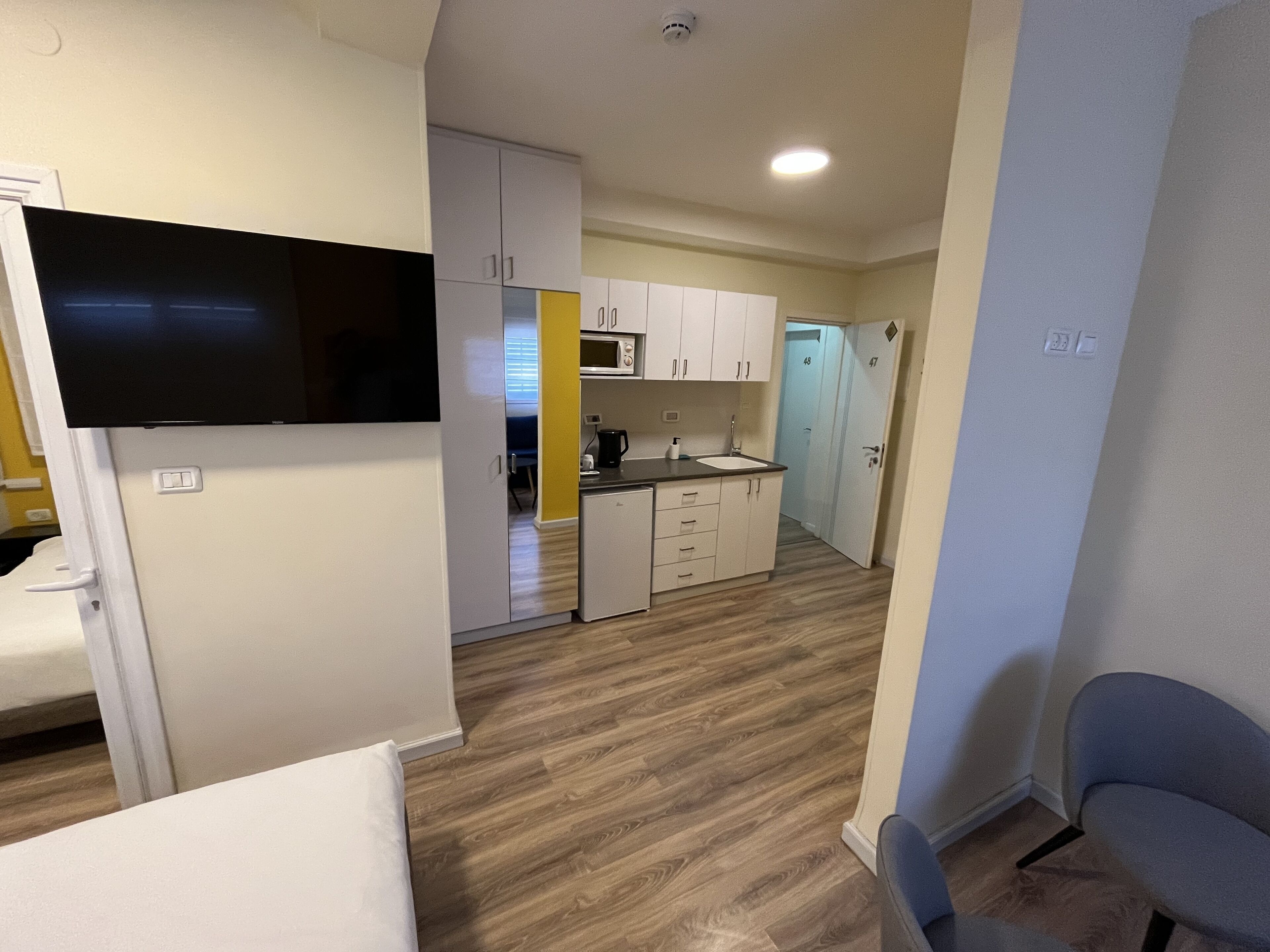 A compact kitchen with white cabinets, a microwave, and a sink.