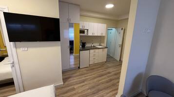 A compact kitchen with white cabinets, a microwave, and a sink.
