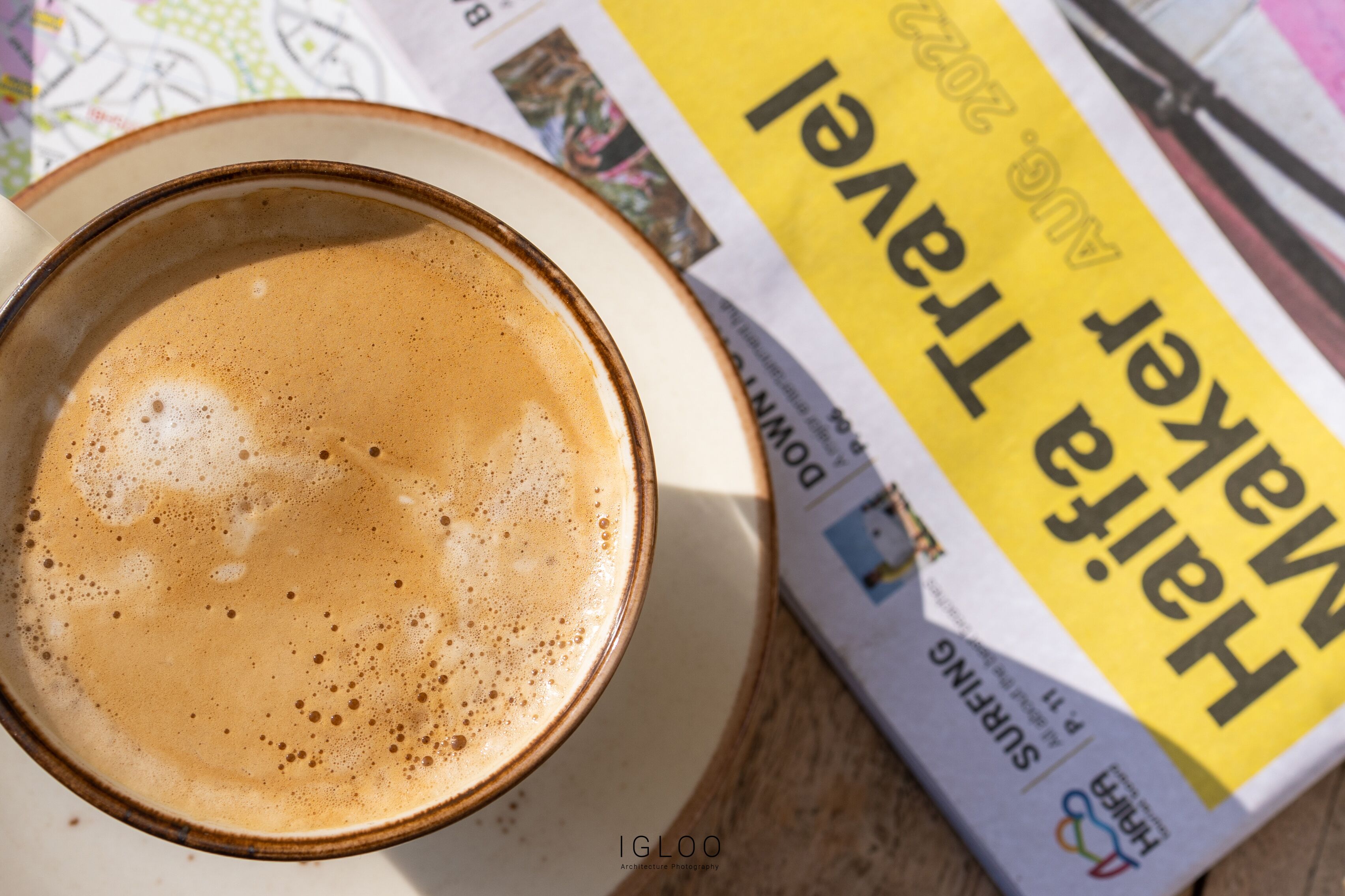 A cup of coffee on a plate with a newspaper titled "Harlequin" in the background.