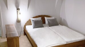 A bedroom with a wooden bed, white bedding, a nightstand, and three pendant lights. - Apartment in the wine and leisure idyll of Klöch. (Klöch)