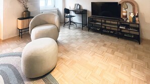 A spacious living room with a high ceiling, a large TV, and a comfortable seating area. - Apartment in the wine and leisure idyll of Klöch. (Klöch)