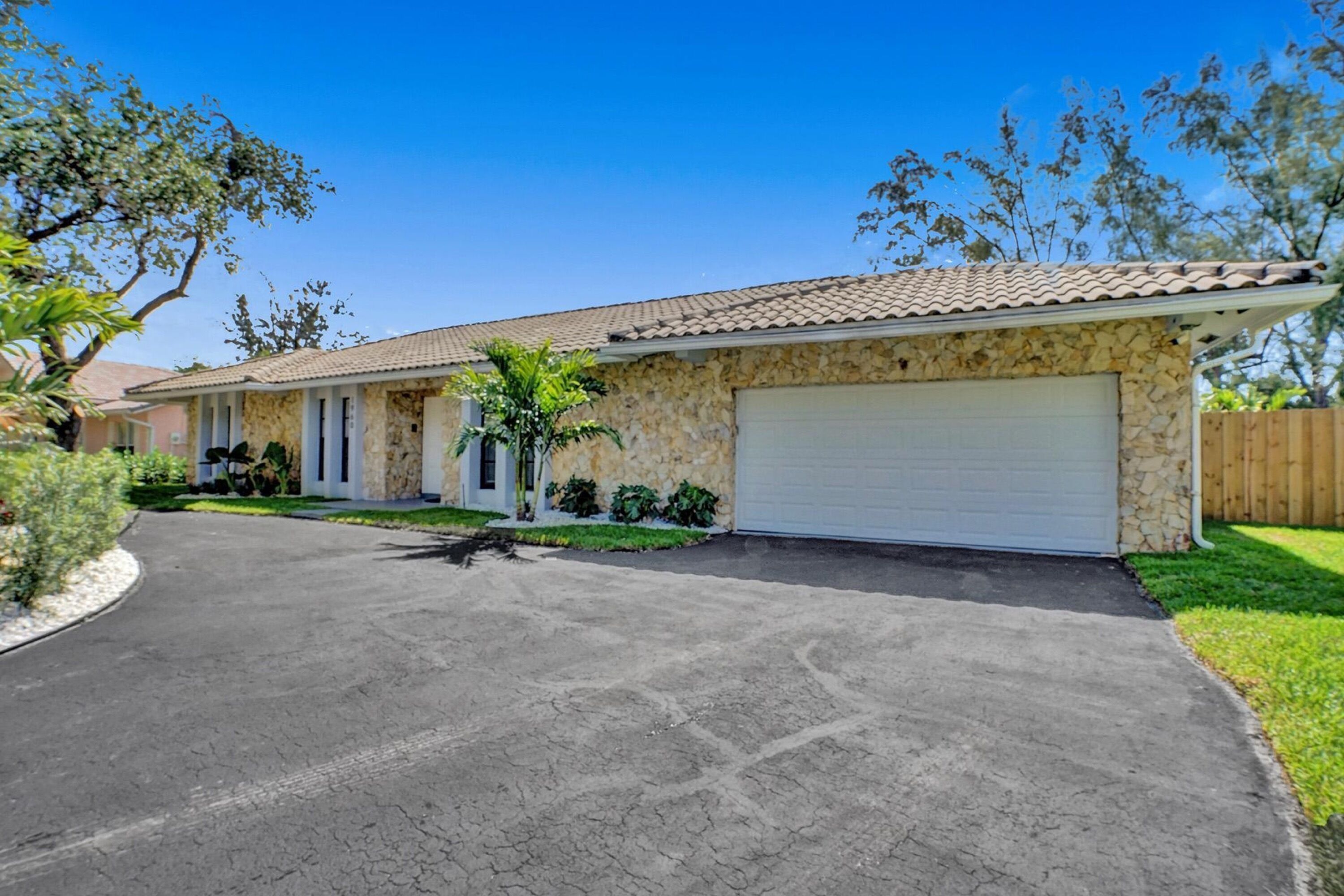 A residential house with a stone facade, a tiled roof, and a garage.
