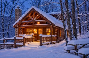 A log cabin with a snow-covered roof and a wooden porch. - 3 BR/2.5 BA NEAR PARKWAY, GAME ROOM, FIREPLACE, HOT TUB,REAL LOG CABIN,PETS OK! (Pigeon Forge)