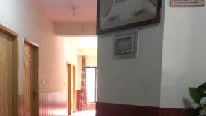 Un área de recepción con alfombra roja, un mostrador y un letrero que indica la recepción.