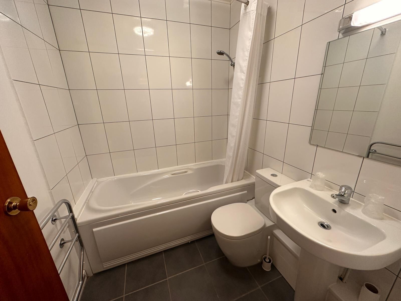 A bathroom with a bathtub, toilet, and sink.
