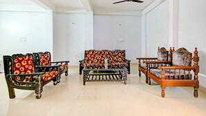 A room with a sofa set, a coffee table, and a ceiling fan. - Hotel Royal Avenue By F9 Hotels (New Delhi)