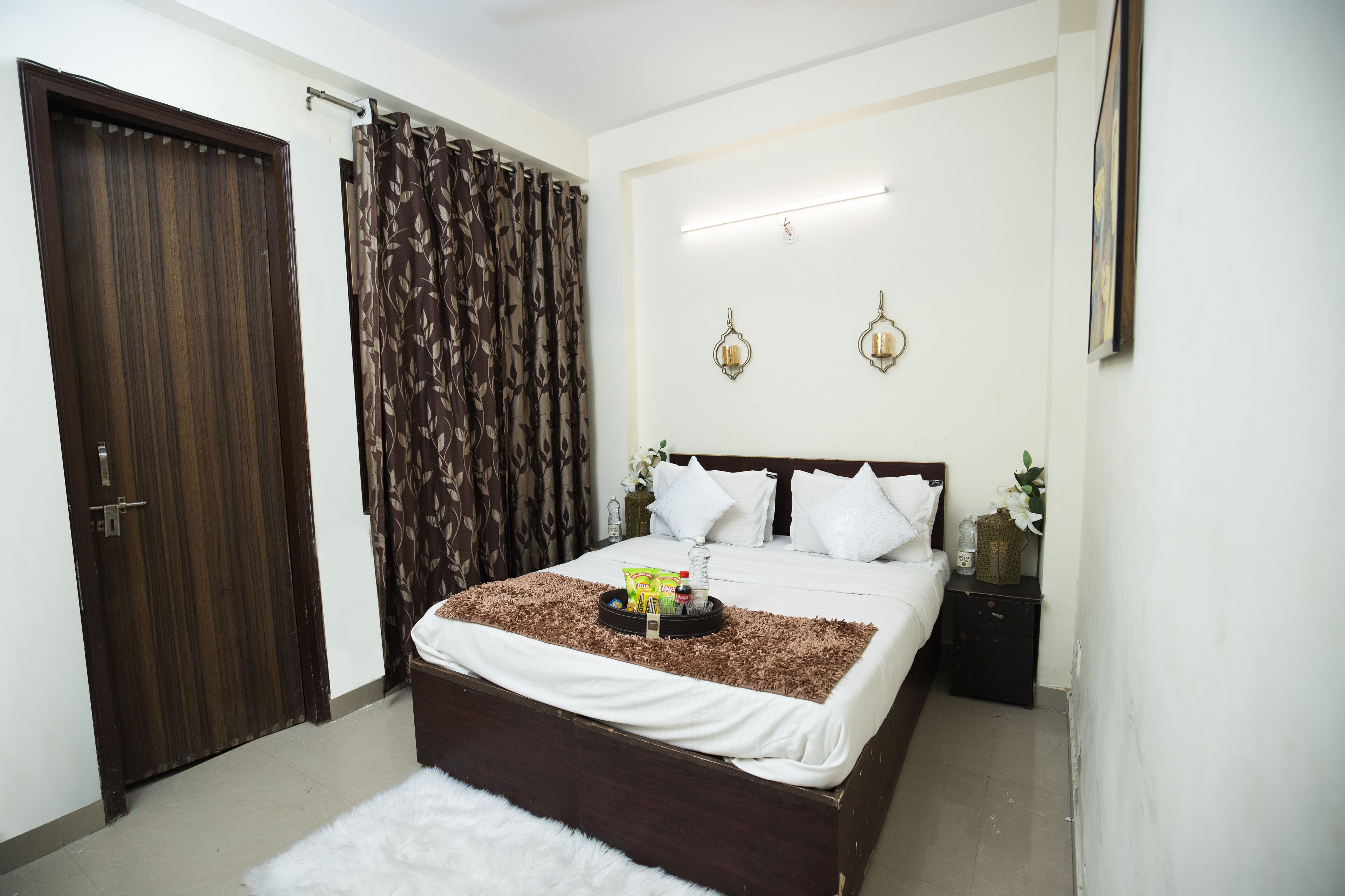 Un dormitorio con una cama grande, una puerta de madera y una cortina.