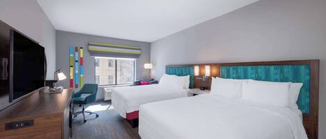 A hotel room with two beds, a desk, a TV, and a window with a view.