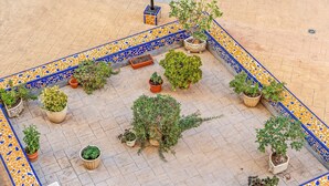 A courtyard with potted plants arranged in a geometric pattern, a tiled floor, and a decorative border. - Holiday Apartment 200 m from the Beach (Torrevieja)