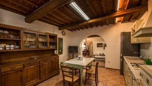 Una cocina con armarios de madera, una mesa de comedor y sillas.