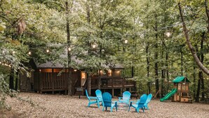 Une cabane dotée d’une terrasse et d’un espace salon extérieur.