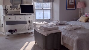 A neatly made bed with white linens, a television on a white dresser, and a window with a view of the outside. - Bijoux Cottage in Porthleven  5 mins walk  Beach/Harbour. Sleeps 2. Dog Friendly (Porthleven)