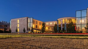 Un complejo moderno de edificios con varias estructuras, incluyendo una fachada de vidrio curvada y un edificio rectangular con techo plano.