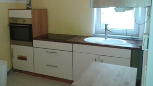 A kitchen with a window, a sink, and a stove. - Pension Yildirim - quiet and central vacation apartment (1) (Leverkusen)