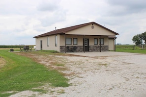 A single-story building with a gabled roof, a front door, and a small porch area. - Prairieview Cottage Retreat - Hot Tub Sunsets (Sullivan)