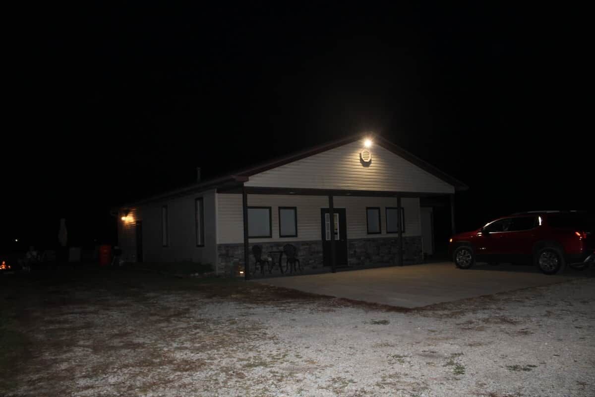 A building with a garage door, a driveway, and a parked car.