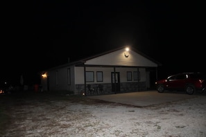 A building with a garage door, a driveway, and a parked car.