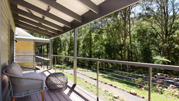 A covered outdoor deck with a view of a forested area. - Rainforest River Studio Kangaroo Valley (Upper Kangaroo River)