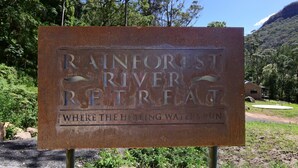 Une enseigne pour le « Rainforest River Retreat » avec l’inscription : « Là où coulent les eaux aux vertus curatives. »