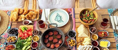 A table set with various foods, including bread, cheese, and olives, with a decorative fish plate.