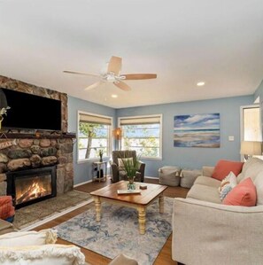 Cozy living room with a fireplace, sofa, and armchairs, perfect for relaxing.