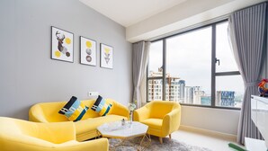 Ein modernes Wohnzimmer mit einem gelben Sofagarnitur, einem weißen Couchtisch und einem großen Fenster mit Blick auf die Stadt.