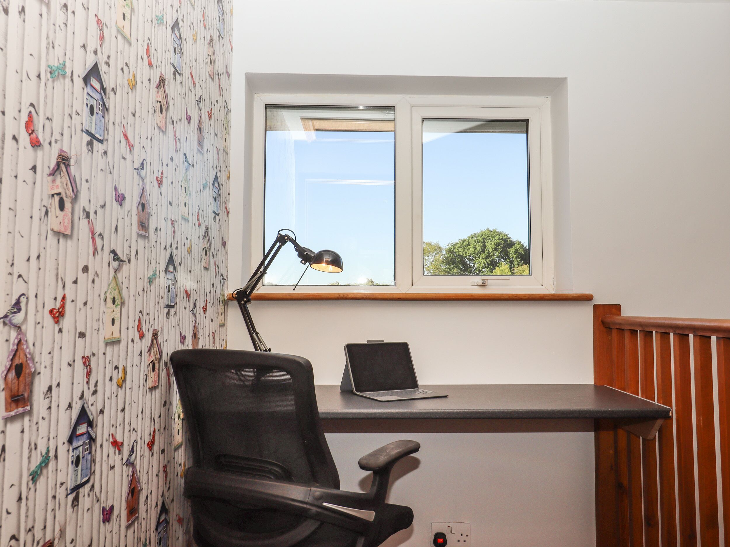 Un petit bureau comprenant un bureau, une chaise et une fenêtre.