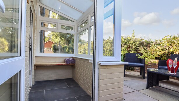 A corner room with a glass door leading to a patio area. - Albies End (Battle)