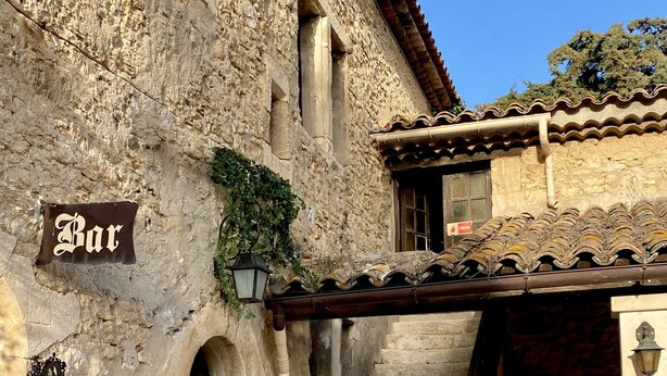 A stone building with a sign reading "Bar" and a staircase leading to an upper level. - Domaine de la Reynaude (Aurons)