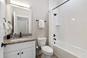 A modern bathroom with a white sink, toilet, and bathtub. - SunRay Cottage: 3 Bed/2 Bath/Convenient Location! (St. Augustine)