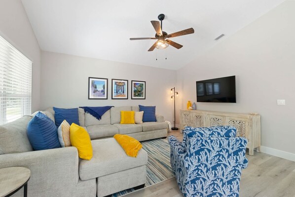 A living room with a sofa, armchair, and a ceiling fan. - SunRay Cottage: 3 Bed/2 Bath/Convenient Location! (St. Augustine)