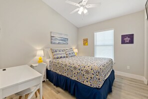 A bedroom with a bed, a desk, a ceiling fan, and a window with blinds. - SunRay Cottage: 3 Bed/2 Bath/Convenient Location! (St. Augustine)