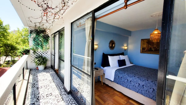 A bedroom with a bed, nightstands, and a view through a glass door. - 2D Apartment Impeccable - Air Conditioned - Metro Los Héroes (Santiago)