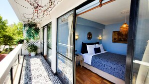 Ein Schlafzimmer mit Bett, Nachttischen und Blick durch eine Glastür.