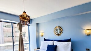 A bedroom with a large bed, a hanging light fixture, and a view of the outside through a window. - 2D Apartment Impeccable - Air Conditioned - Metro Los Héroes (Santiago)
